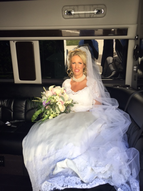 Local wedding transportation service in Chicagoland, Bride seated inside a stretch limousine holding a wedding bouquet, from Stop & Go Limo Airport Shuttle Service.