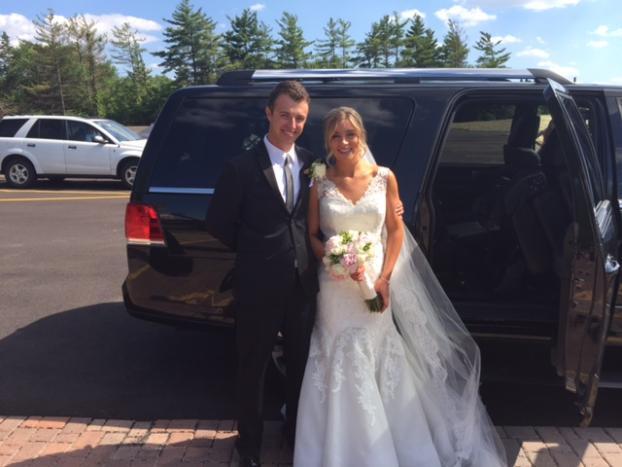 Local wedding transportation service in Chicagoland, Wedding couple outside a luxury SUV surrounded by trees, from Stop & Go Limo Airport Shuttle Service.